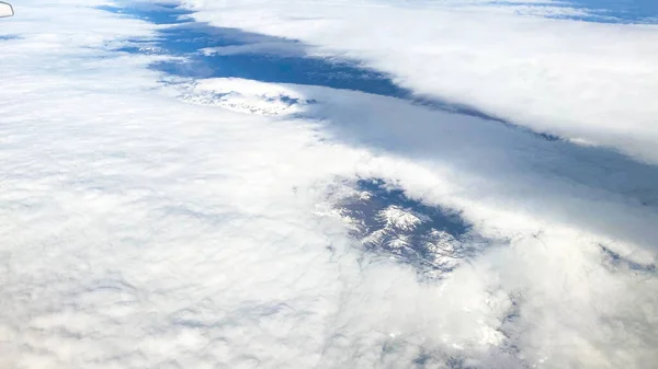 Vista aérea. Nuvens brancas no céu azul. Vista de belas nuvens de uma janela de avião . — Fotografia de Stock