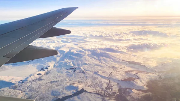 A vista do avião na paisagem a partir da janela do avião. asa do avião voando acima das nuvens — Fotografia de Stock