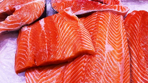 Steki świeżego łososia na ladzie w lodzie. Surowa czerwona ryba na sprzedaż. Sklep z owocami morza. — Zdjęcie stockowe
