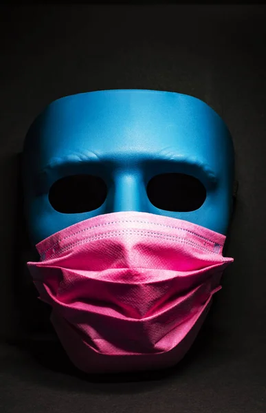 Medicinsk rosa mask på en blå mask. svart bakgrund — Stockfoto