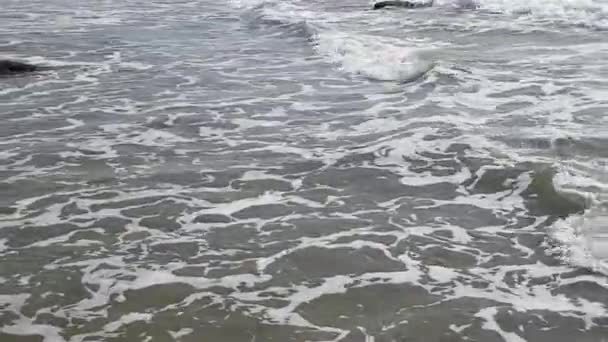 Grävande vågor av havstvätt enorma utskjutande stenar nära stranden — Stockvideo