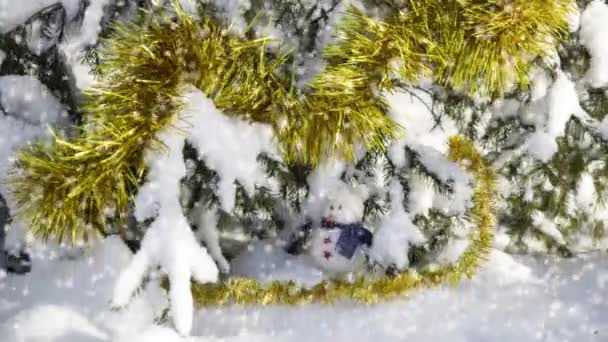 ゴールド見掛け倒しで飾られた雪ツリーの下の小さなおもちゃ雪だるまのクリスマス カード — ストック動画