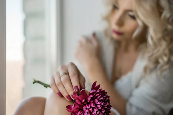 Sad girl sitting on a window sill — Stock Photo, Image