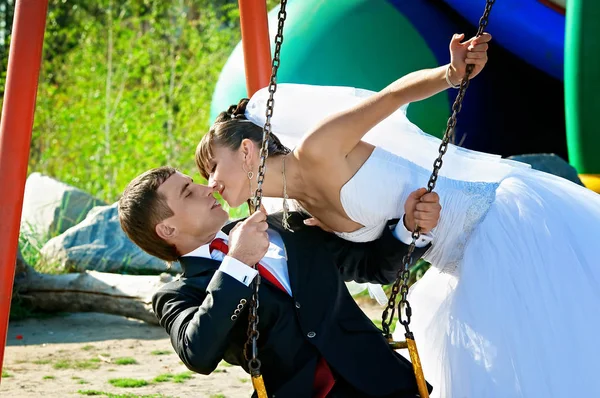 Newlyweds swing on a swing — Stock Photo, Image