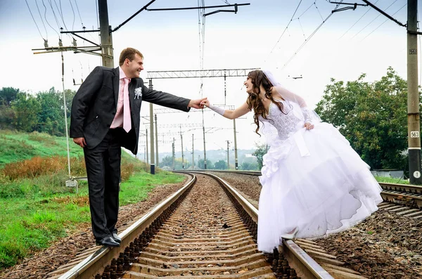 Recém-casados caminhando na ferrovia — Fotografia de Stock