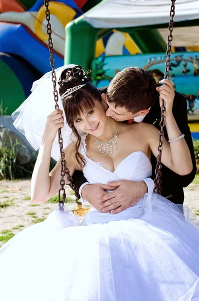 Newlyweds swing on a swing — Stock Photo, Image