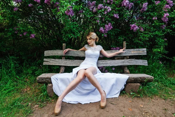 Elegantní módní model v bílých šatech, pózuje v parku — Stock fotografie