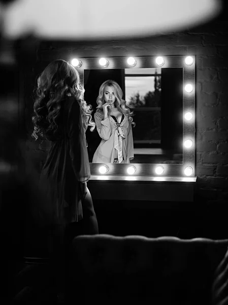 Luxury blonde flirts at the mirror (black and white)