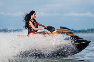 Atletik esmer, denizde jet ski sürüyor.