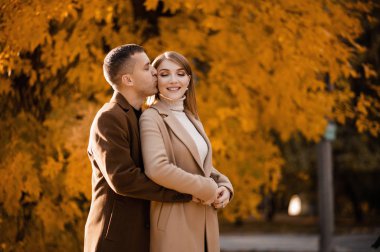 Oak Grove 'daki bir sonbahar parkında yürüyen sevimli bir çift. Sonbahar ormanında fotoşop. Yaprak düşer, sarı yapraklar