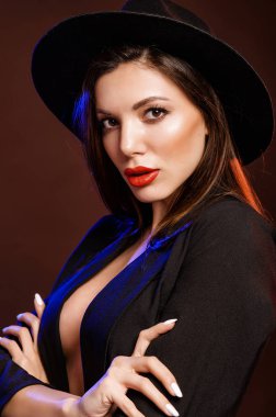 Siyah ceketli esmer ve güzel makyajlı bir şapkası var.