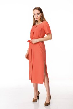 Beyaz bir duvara karşı elbise giymiş çekici bir kız.