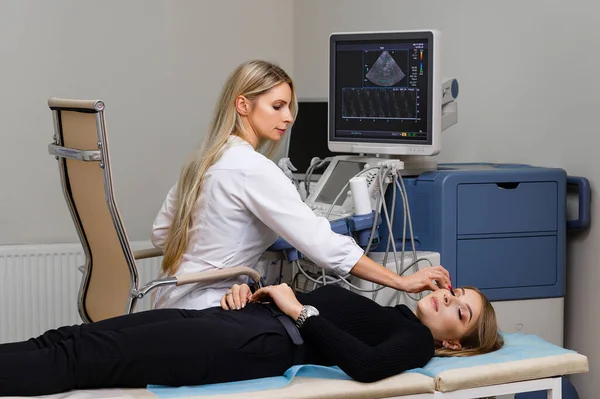 Doctor radiologist at work with an ultrasound machine. Ultrasound examination of the thyroid gland in a patient