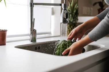 Çekici sarışın mutfakta yemek pişiriyor.