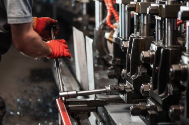 Metal ürünlerin üretimi. İşçi metal bir değirmen kuruyor.