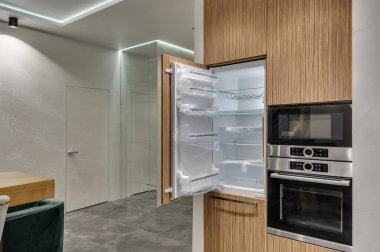 Çok işlevli modern mutfak. Dahili aletler. Yeni buzdolabının kapısı açıldı.