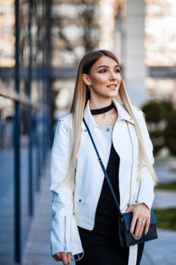 İlkbaharda şehirde yürüyen çekici bir kız.