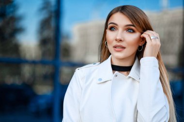 İlkbaharda şehirde yürüyen çekici bir kız.