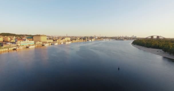 Wspaniały widok na miasto z góry. Duże miasto z mostu nad rzeką i wiele zielonych drzew. Całkowite zachmurzenie. Wiosną. Kijów — Wideo stockowe