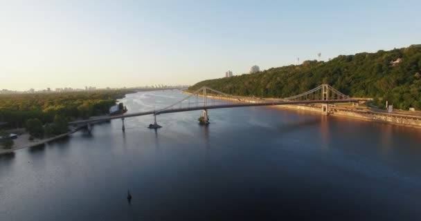 Prachtig uitzicht op de stad van bovenaf. Grote stad met de brug over de rivier en veel groene bomen. Bewolkt. Lente. Kiev — Stockvideo
