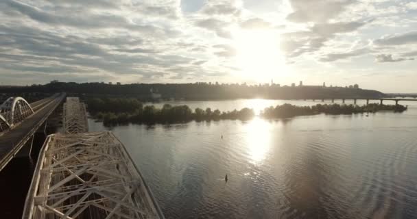 Kiev. Ucraina. Il ponte sul fiume Dnieper Inverno. Supera la città con vista a volo d'uccello al tramonto Lonza. La città di Kiev si trova sul fiume Dnieper. Volare a Kiev sul fiume Dnieper  . — Video Stock