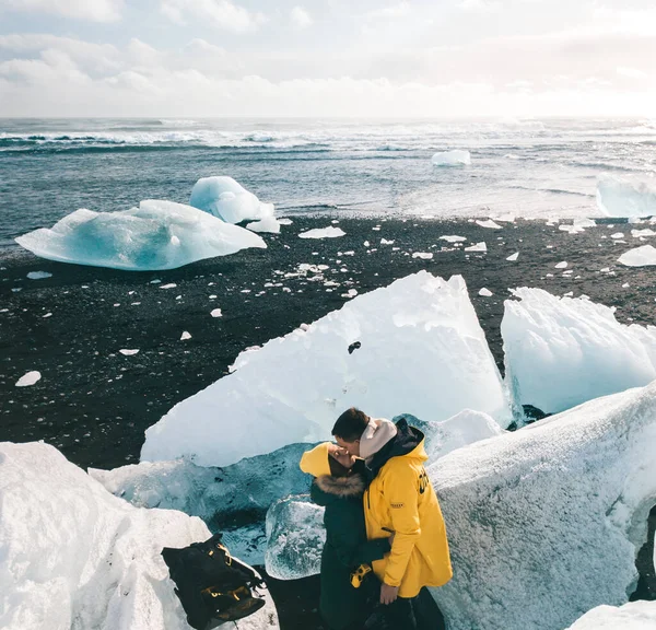 Счастливая стильная улыбающаяся пара, гуляющая и целующаяся в Исландии. Рука, пляж . — стоковое фото