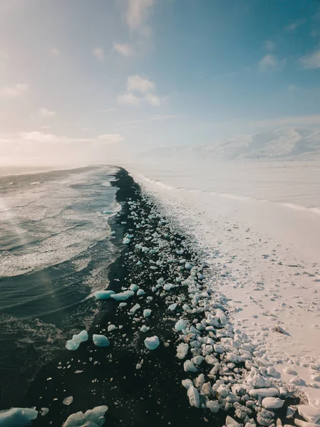 Lodowa skała z czarną piaszczystą plażą na plaży Jokulsarlon. Diamond Beach w Islandii — Zdjęcie stockowe