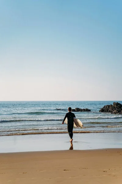 Pensif homme en maillot de bain va dans l'eau avec planche de surf — Photo