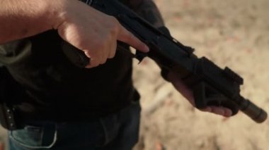 Tanınmayan asker saldırı tüfeğini tutuyor.