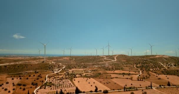 Kıbrıs 'taki ekoloji santralinde büyük rüzgar türbinlerinin etrafında uçuyorlar. Adanın kırsal kesimindeki çayırlarda istasyon inşaatının insansız hava aracı görüntüsü. — Stok video