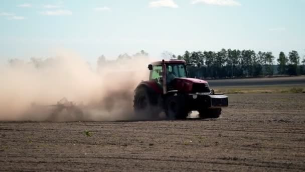 Große Sicht auf den Traktor. Landwirtschaftliche Traktoraussaat und Ackerbau. Traktor bei Sonnenuntergang auf dem Feld. — Stockvideo