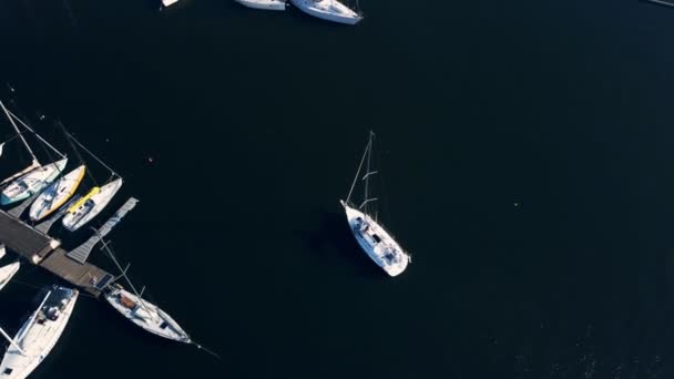 Un yacht sous le drapeau ukrainien avec une voile abaissée sur un moteur quitte le port des navires fluviaux en direction du chenal de la rivière. Tournage vidéo Aero . — Video