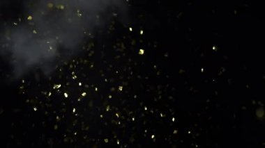 Turkuaz bir balon fırlar ve havaya parıltı ve konfeti saçar, ağır çekimde.