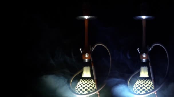 Tres hermosas hookahs aparecen sobre un fondo negro en humo multicolor, cámara lenta — Vídeos de Stock