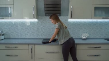 Kız sobayı yıkıyor ve mutfak çok yorgun.