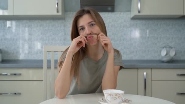 La chica mira a la cámara y las curvas, en casa en la cocina — Vídeos de Stock