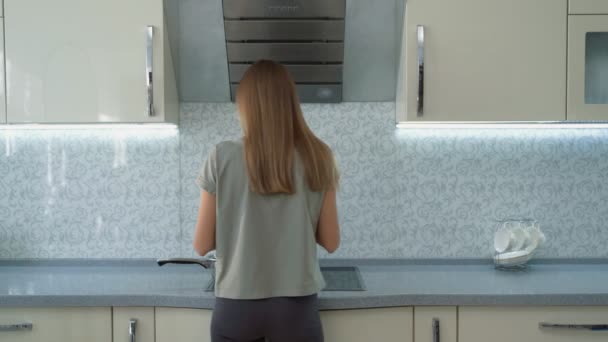 Junge, schöne Frau probiert leckere Suppe stehend in der Küche — Stockvideo