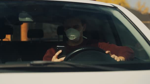 Cara mascarado faz uma chamada de vídeo a partir de um celular digital enquanto sentado em um carro — Vídeo de Stock