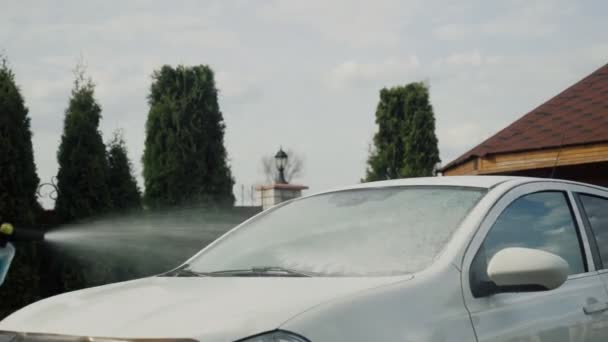 Jet foam shoots at white car windshield — Stock Video