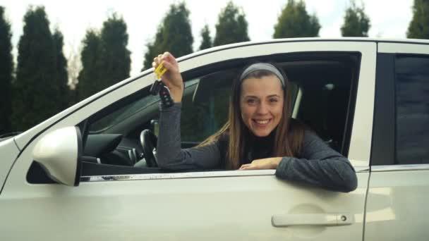 Linda chica dio un coche blanco ella es muy feliz — Vídeo de stock