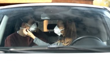 Kız maskeyi arabada oturan, ön camdan bakan virüslü adama göre ayarlıyor.