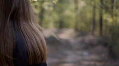 Güzel kız ormanda yürüyor. Yakın plan.