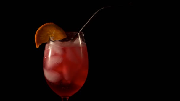 Red cocktail with ice and orange and straw. Close-up — Stock Video