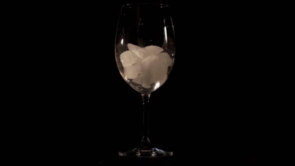 Много льда падает в стакан, затем бармен наливает жидкость в апельсиновый коктейль со льдом и добавляет кусочек апельсина — стоковое видео