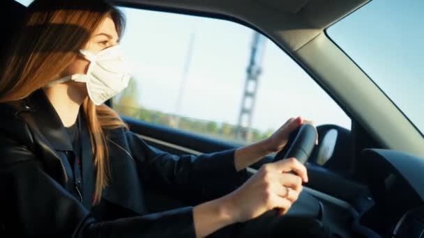 Meisje rijdt auto met een medisch masker — Stockvideo