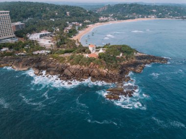 Mirissa 'nın batısındaki Hindistan cevizi palmiye tepesinde bulutlu bir gündoğumunda, Sri Lanka' da tropik bir plaj..