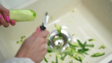 Kadınlar lavaboda salatalık temizler.