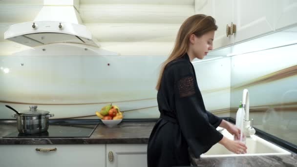 Mujer bonita lava platos en la cocina — Vídeo de stock