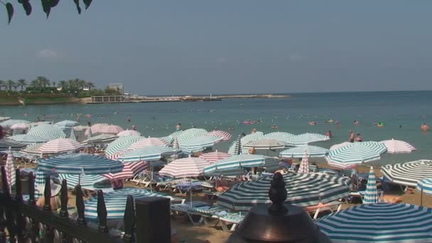 Türkei, Antalya, 20. August 2015: Strand, Sonnenschirme, Menschen schwimmen und sonnen sich am Strand — Stockvideo