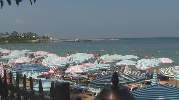 Türkei, Antalya, 20. August 2015: Strand, Sonnenschirme, Menschen schwimmen und sonnen sich am Strand — Stockvideo